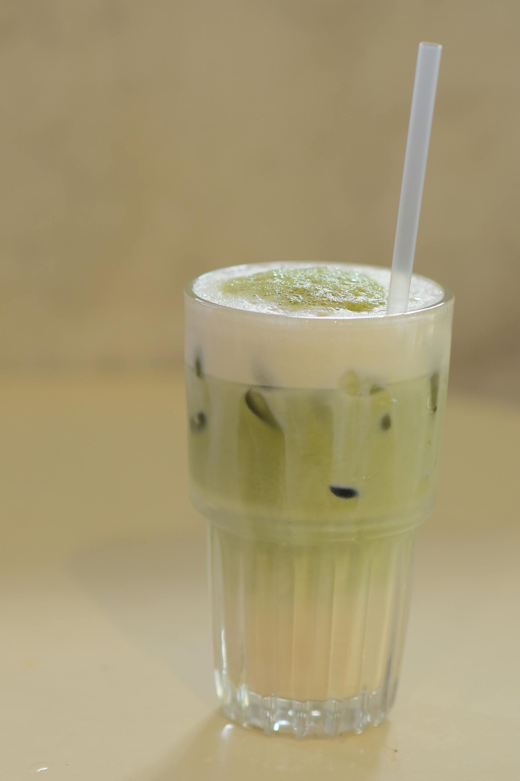 A fresh iced matcha latte in a glass with a straw, perfect for a mid-day refreshment.